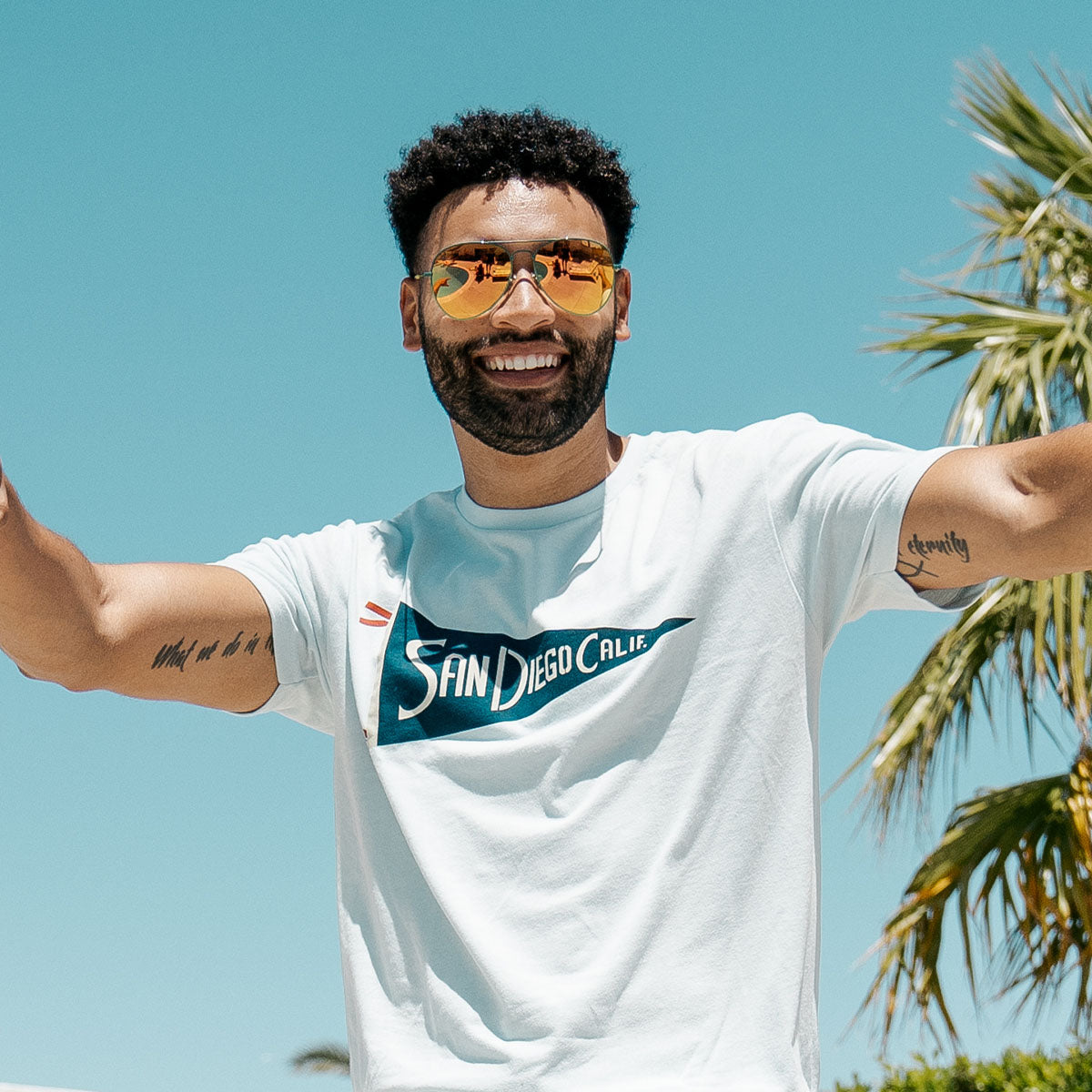 Man smiling while wearing Knockaround Mount Evans aviator sunglasses