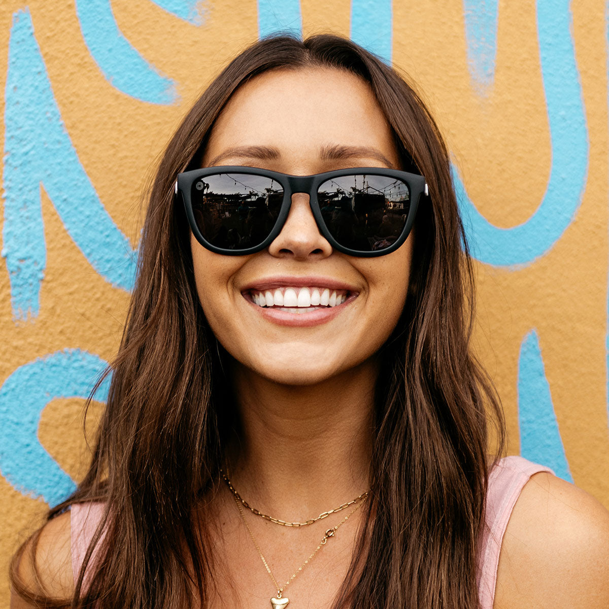 woman smiling and wearing sunglasses