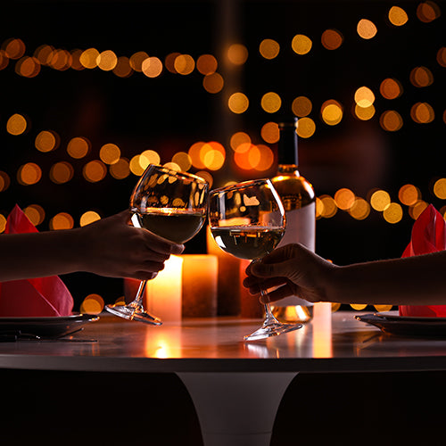 Couple with glasses of wine having romantic candlelight dinner