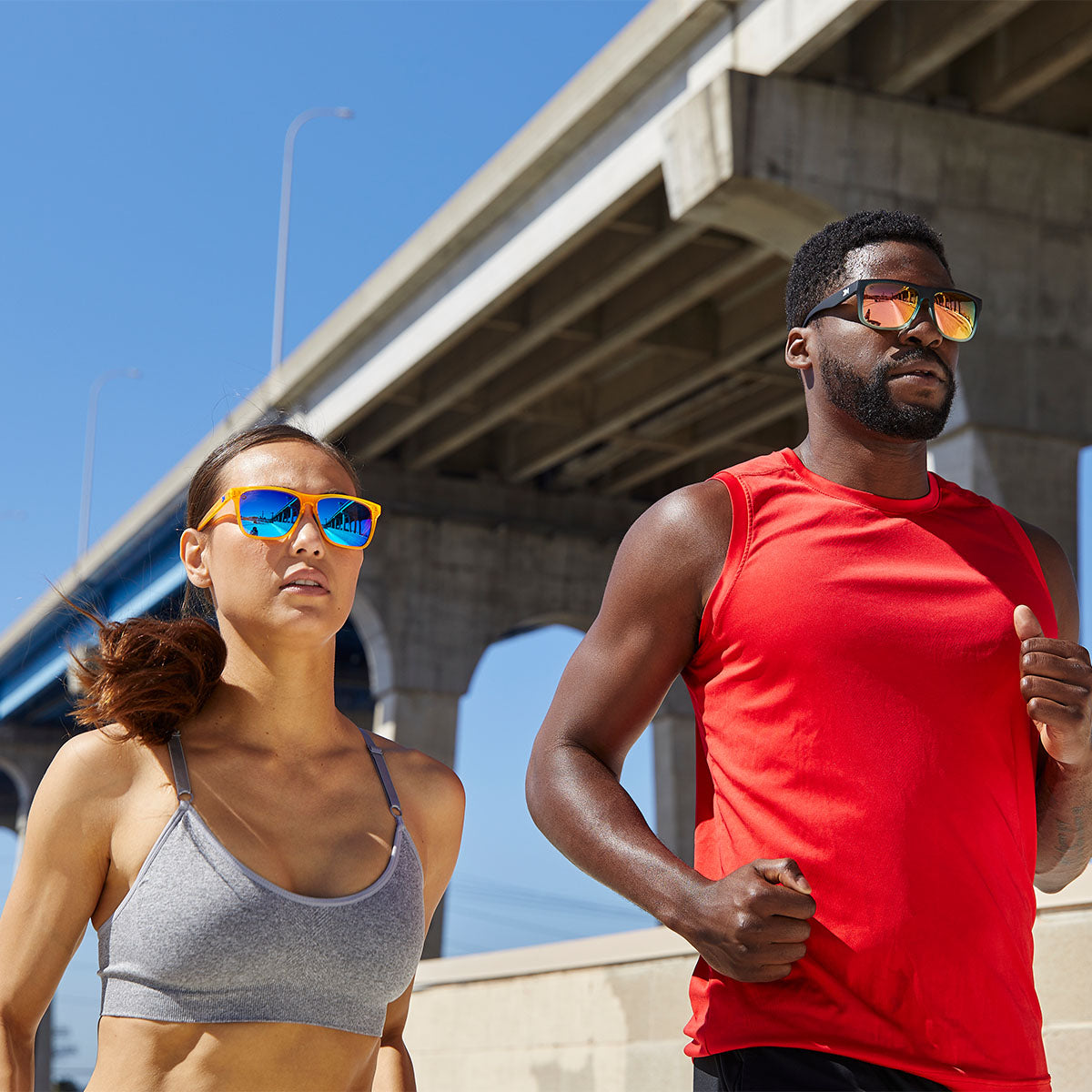 Two people running while wearing Knockaround Sport sunglasses