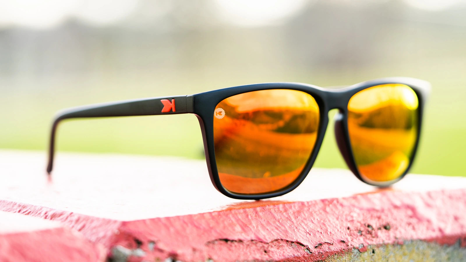 Lifestyle photo of Matte Black / Red Sunset Fast Lanes Sunglasses