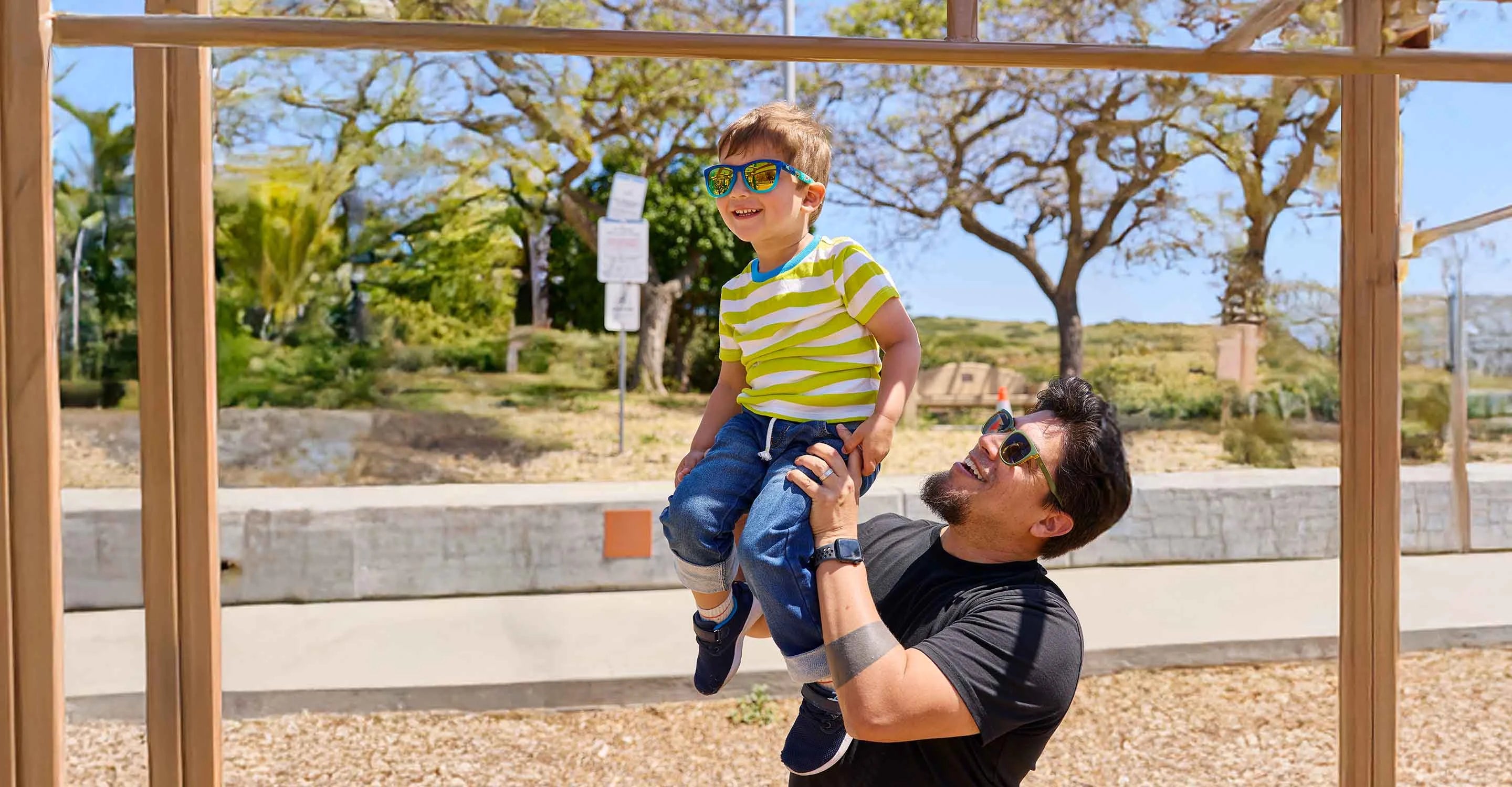 Father and son wearing Knockaround sunglasses in the park