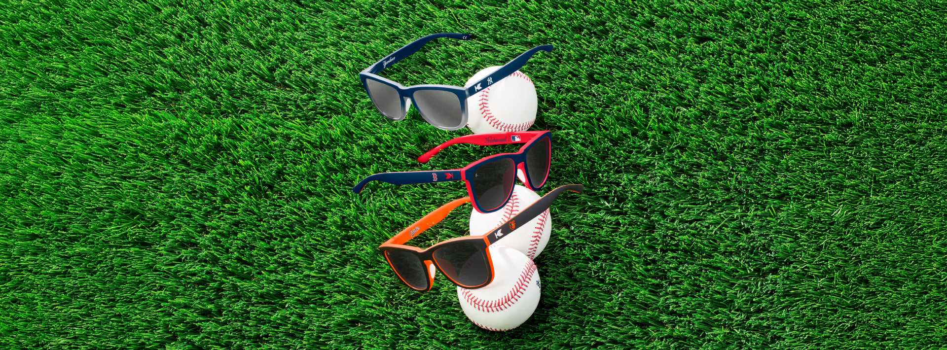 MLB Sunglasses on grass. Pictures are: New York Yankees, Boston Red Sox, and Baltimore Orioles Premiums Sport sunglasses