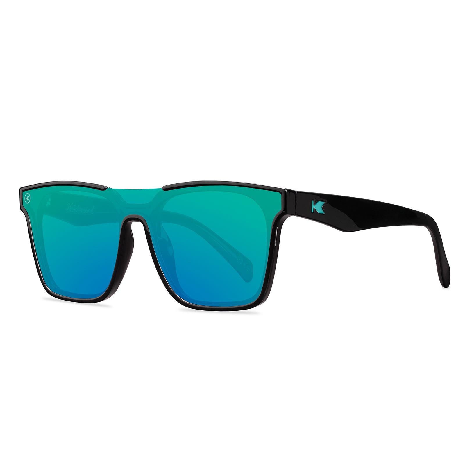 Sunglasses with a black frame with polarized green lenses, threequarter