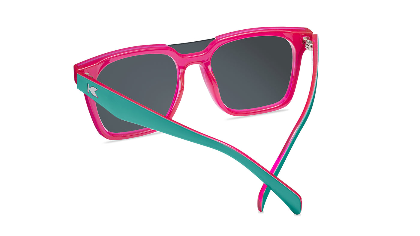 Sunglasses with a teal and pink frame with polarized pink and purple lenses, back