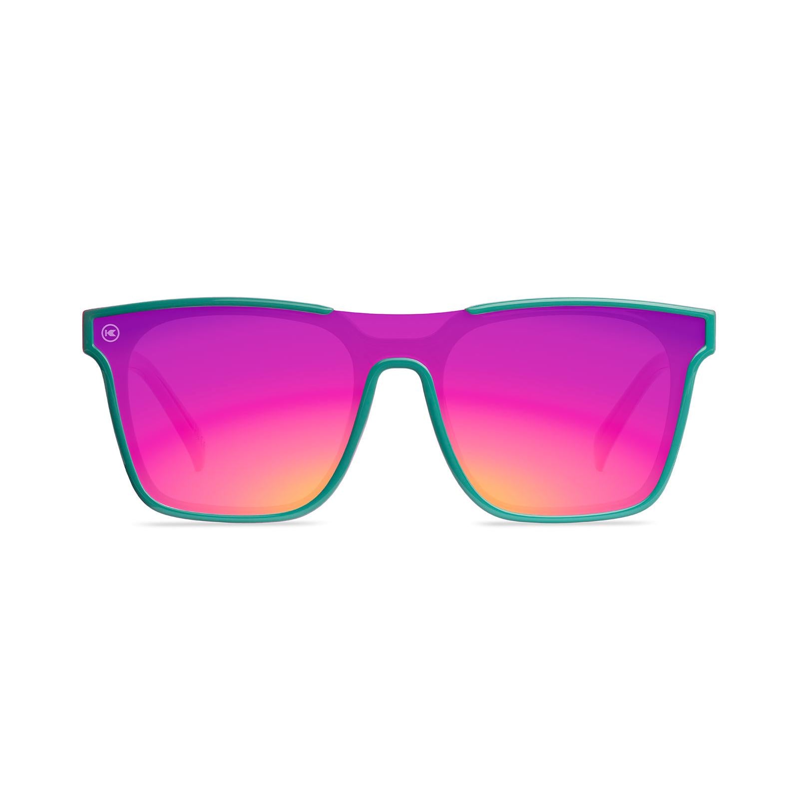 Sunglasses with a teal and pink frame with polarized pink and purple lenses, front