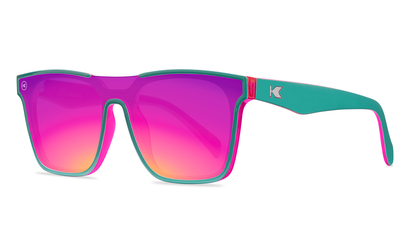 Sunglasses with a teal and pink frame with polarized pink and purple lenses, threequarter