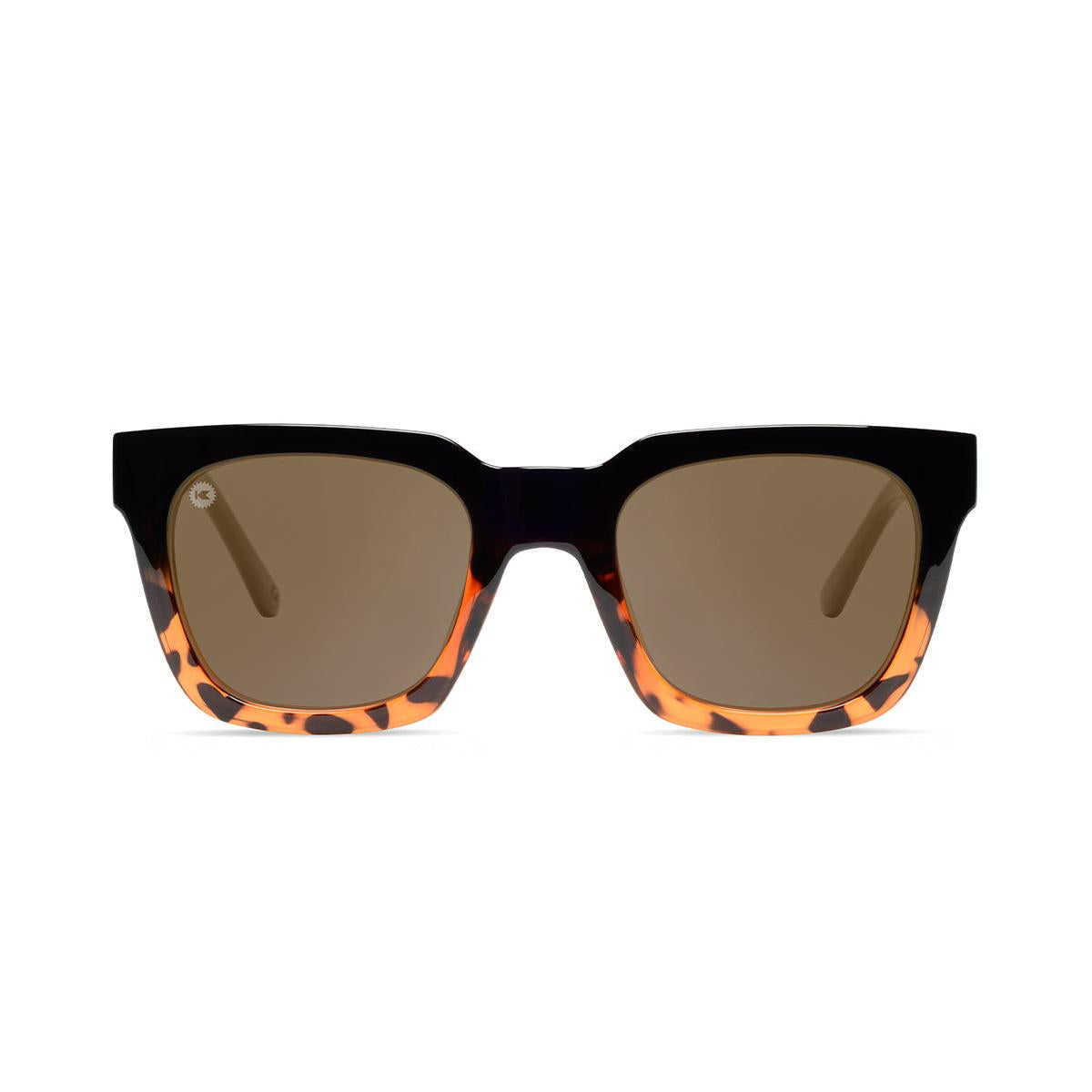 Sunglasses with a glossy black and tortoise shell frame with polarized amber lenses, front