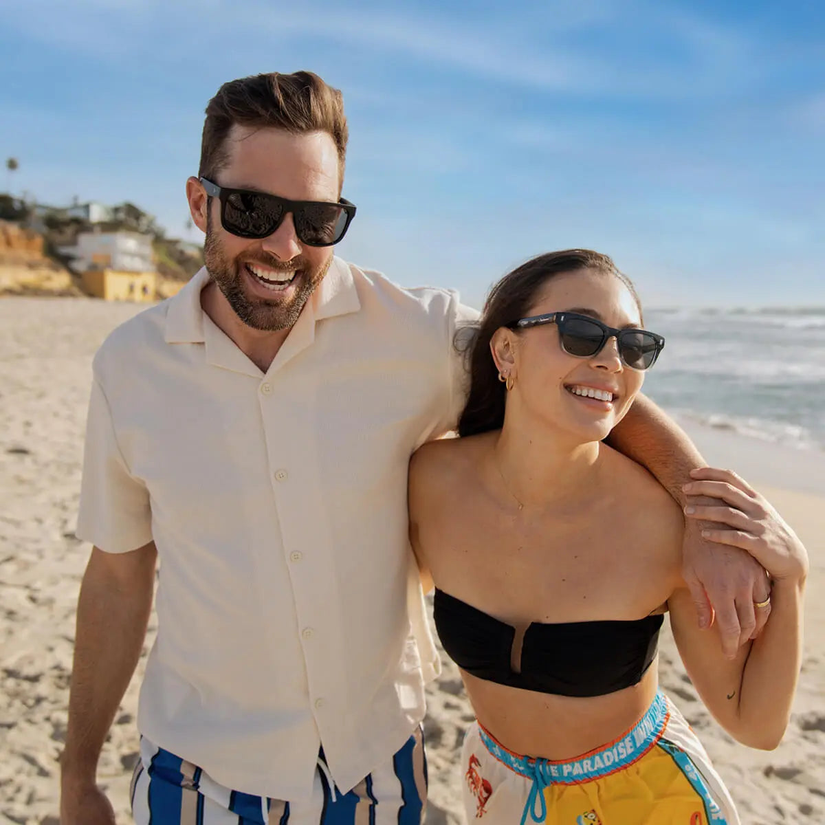 Man and woman at the beach wearing Knockaround sunglasses