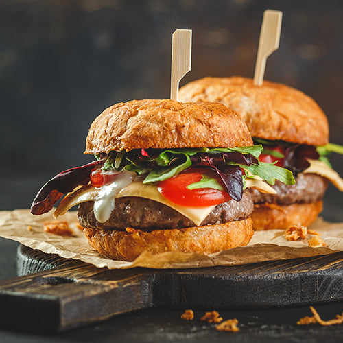 Two hamburgers on a wooden board