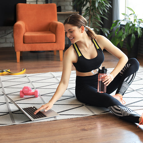 Woman sitting on the floor and working out at home