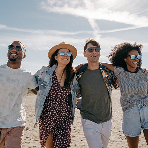 Group of friends wearing Knockaround sunglasses at the beach