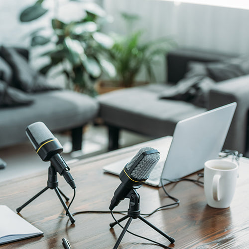 Podcast set up with two microphones and a laptop