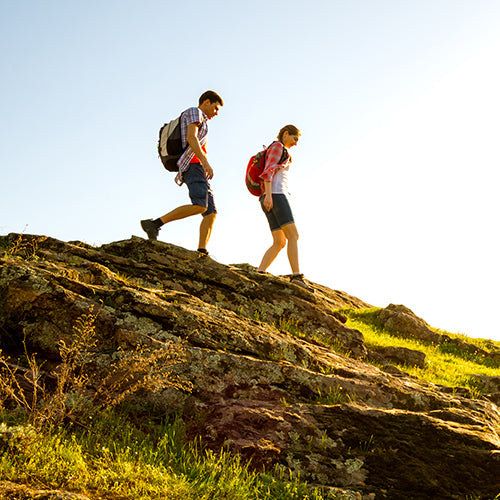 Happy couple hiking with backpacks