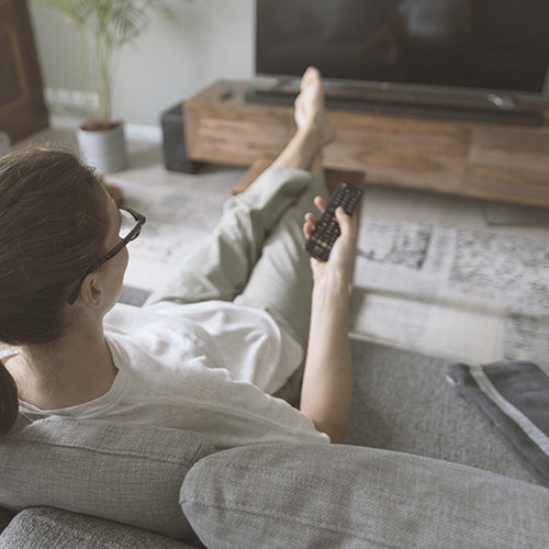 Woman sitting on the sofa and watching TV