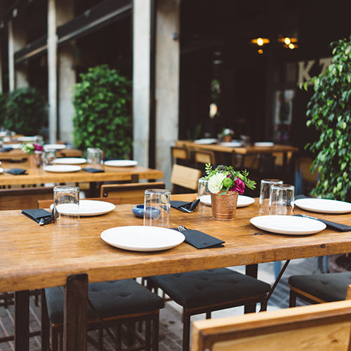 Dishes on the wooden table in outdoor restaurant
