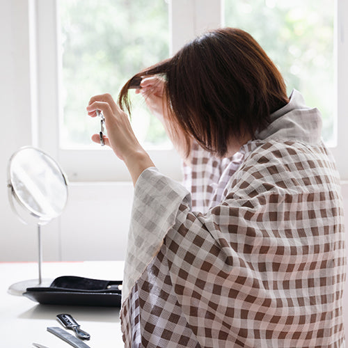 Woman at home giving herself a haircut