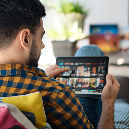Man choosing a movie a stream on a tablet