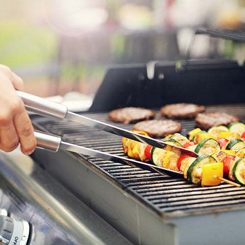 Vegetable skewers and burgers on the grill