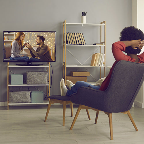 Woman relaxing in chair at home watching television
