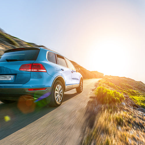 SUV car in Spain mountain landscape road at sunset