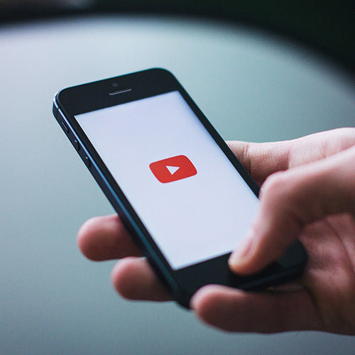 Hand holding smartphone to watch YouTube