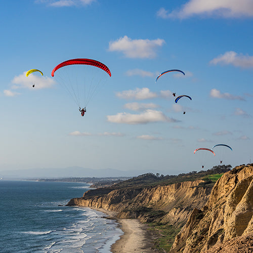 People paragliding over Black's Beach in San Diego