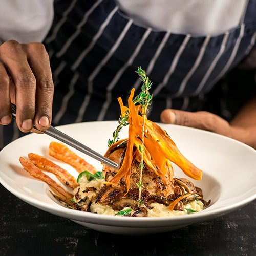Fine dining chef putting finishing touches on dish