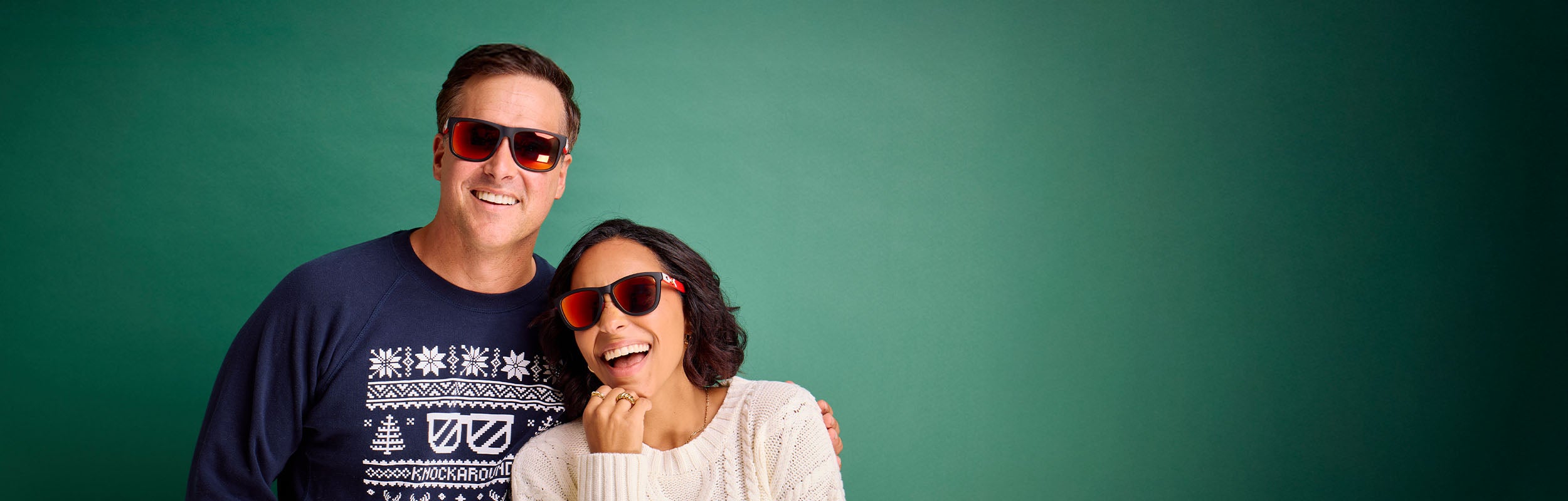 Man and woman wearing Knockaround Santa Claus sunglasses