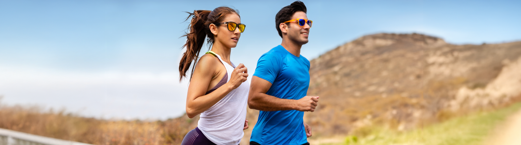 Man and woman running while wearing Knockaround Sport shades