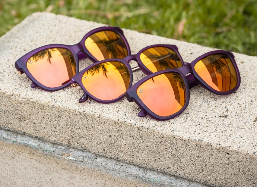 Velvet Royale sunglasses by Knockaround on a ledge over grass