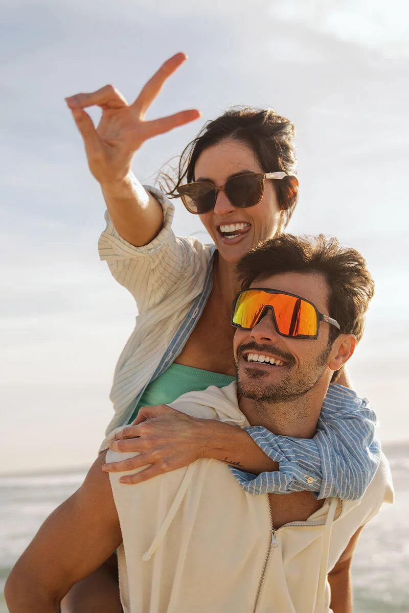 People wearing Knockaround sunglasses at the beach smiling