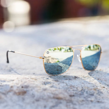 Lifestyle photo of Gold / Sky Blue Mount Evans Sunglasses
