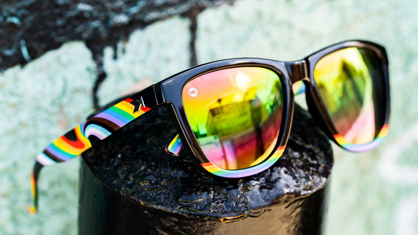 Sunglasses with Glossy black fronts with rainbow accent at bottom, Progress Pride color swirl across arms Silver K-logos Polarized rainbow lenses, Lifestyle