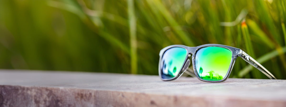 Clear Grey / Green Moonshine Fast Lanes Sport sunglasses photographed in plants