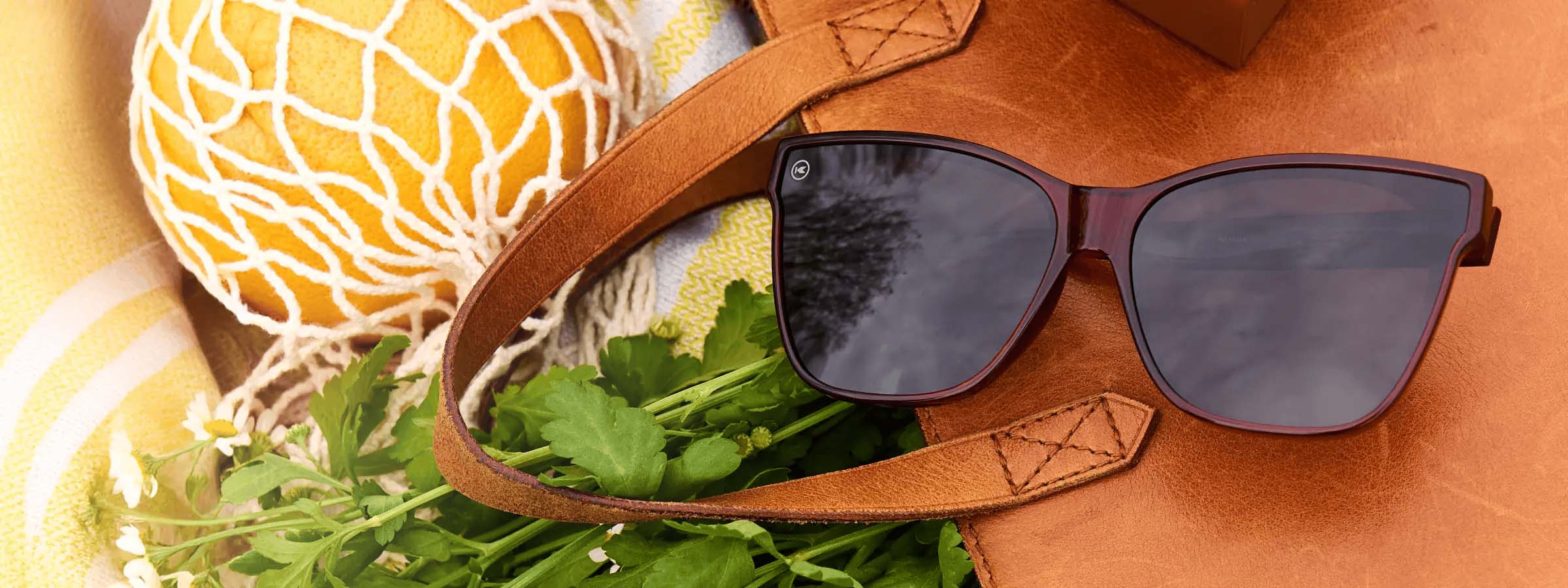 Palomas Sunglasses by Knockaround photographed on a purse with greenery