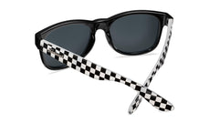 Sunglasses with black and white frames and polarized black smoke lenses