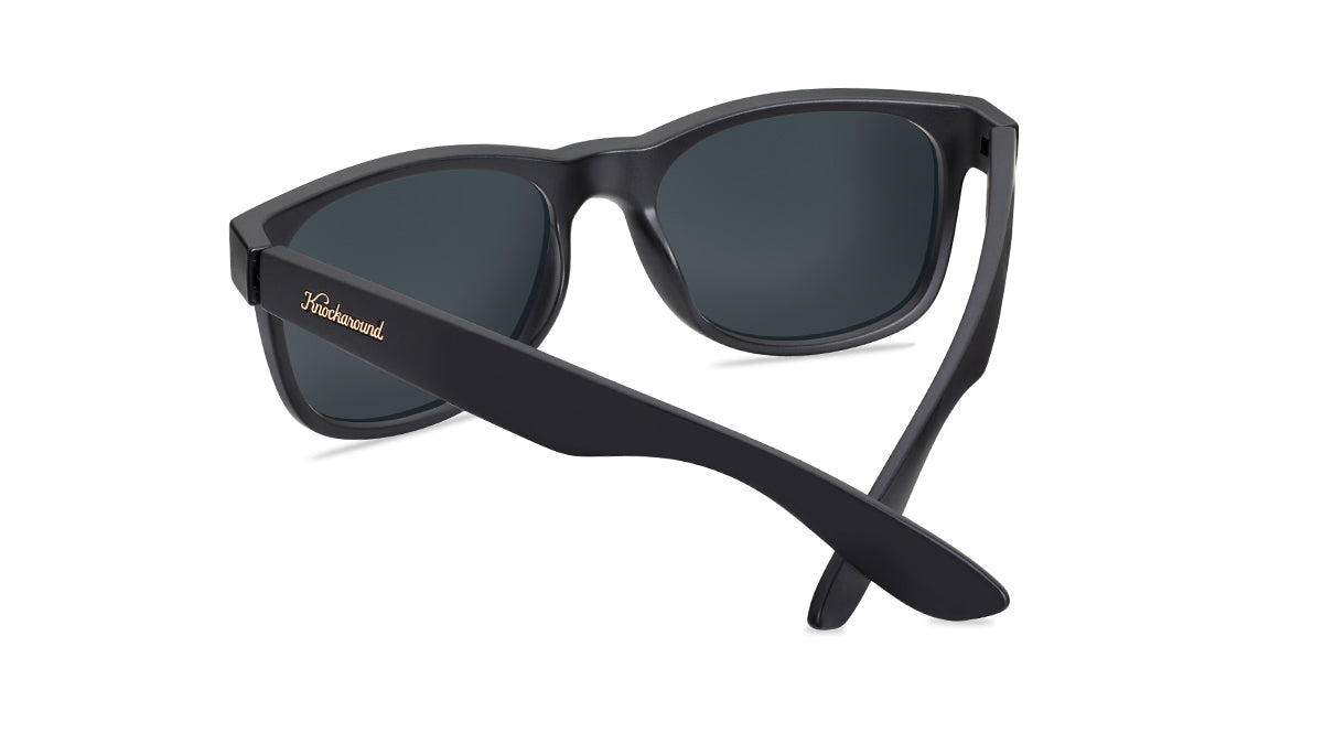 Sunglasses with matte black frames and polarized rose gold lenses. back