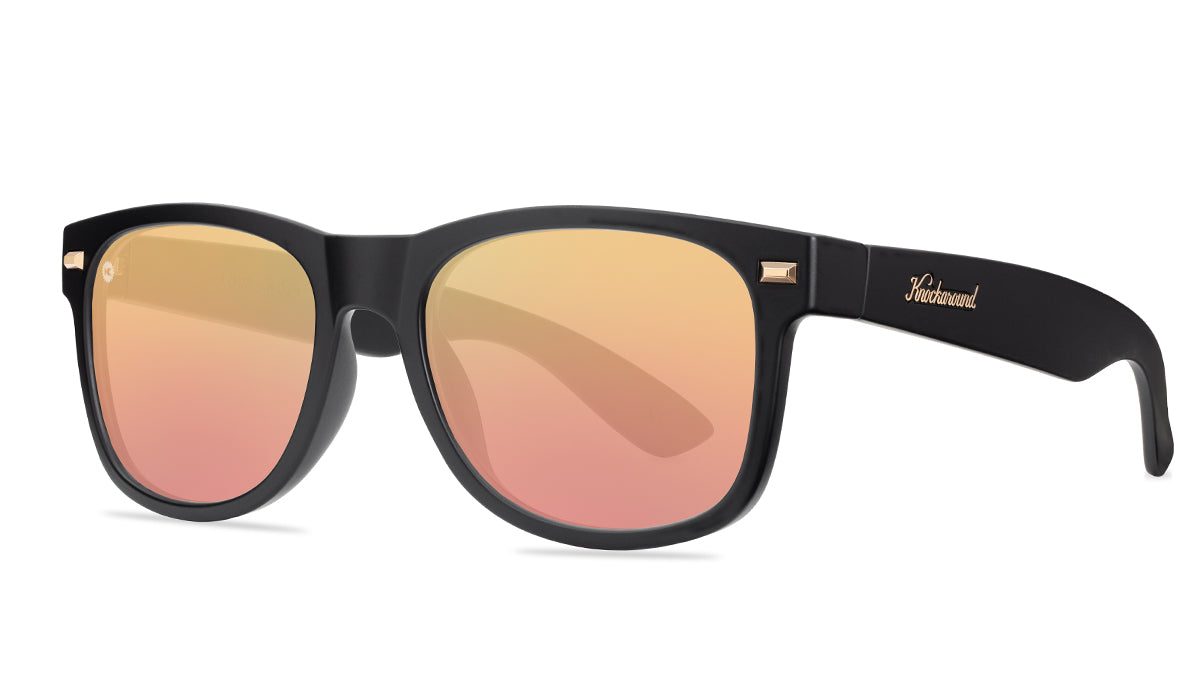 Sunglasses with matte black frames and polarized rose gold lenses. threequarter