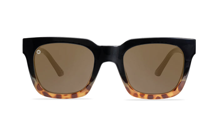Sunglasses with a glossy black and blonde tortoise shell frame with polarized amber lenses, front