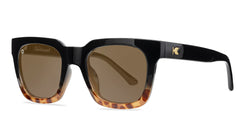 Sunglasses with a glossy black and blonde tortoise shell frame with polarized amber lenses, threequarter