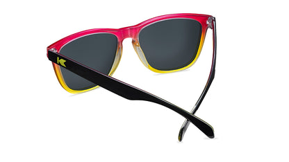 Sunglasses with glossy black frames and polarized pink sunset lenses, back