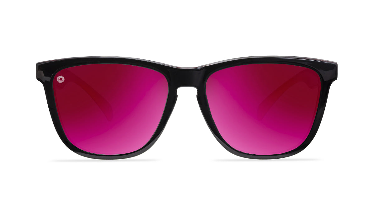 Sunglasses with glossy black frames and polarized pink sunset lenses, front