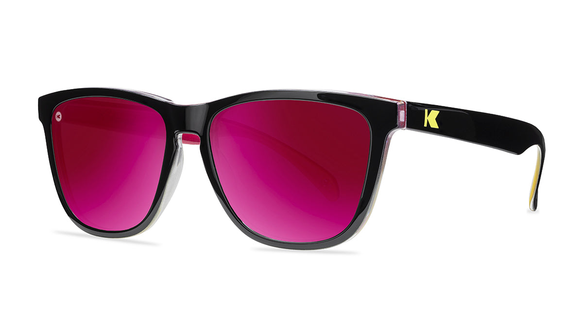 Sunglasses with glossy black frames and polarized pink sunset lenses, threequarter