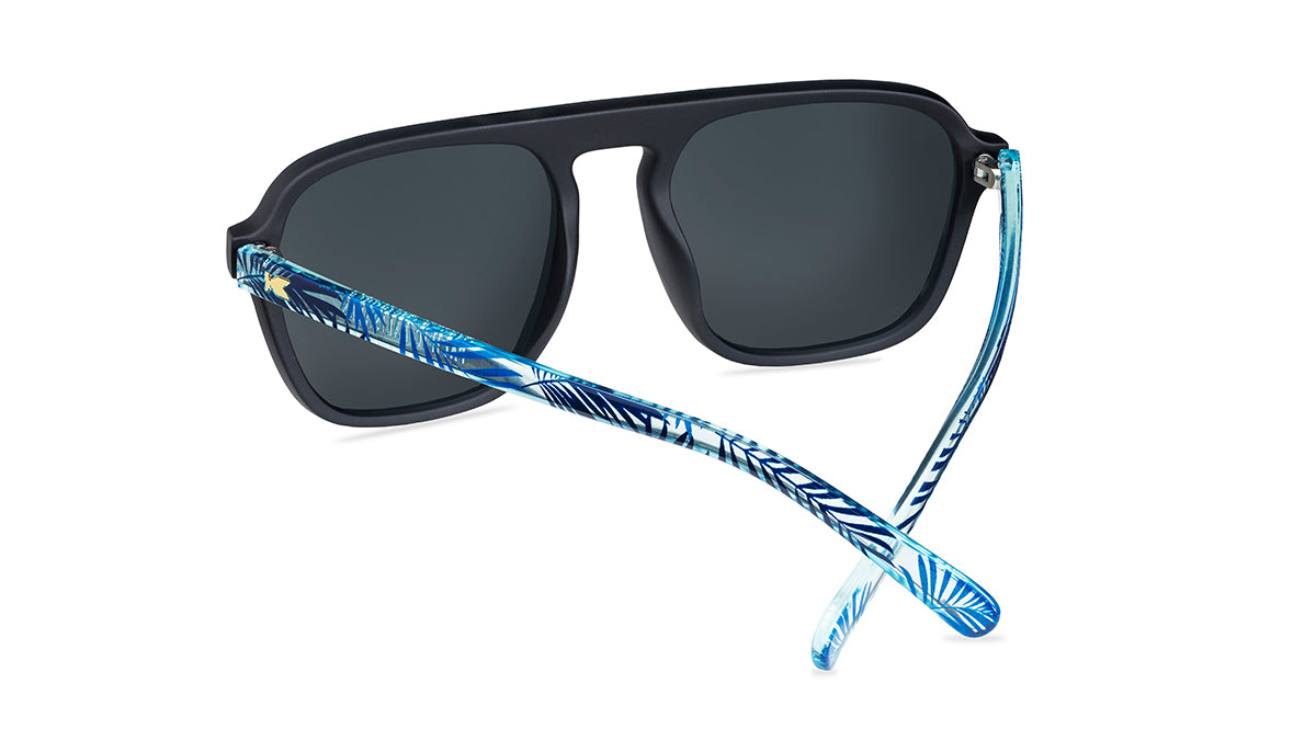 Sunglasses with black fronts, blue palm tree arms and polarized sky blue lenses, back