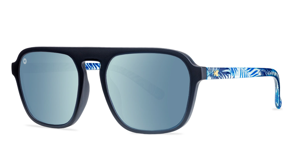 Sunglasses with black fronts, blue palm tree arms and polarized sky blue lenses, threequarter