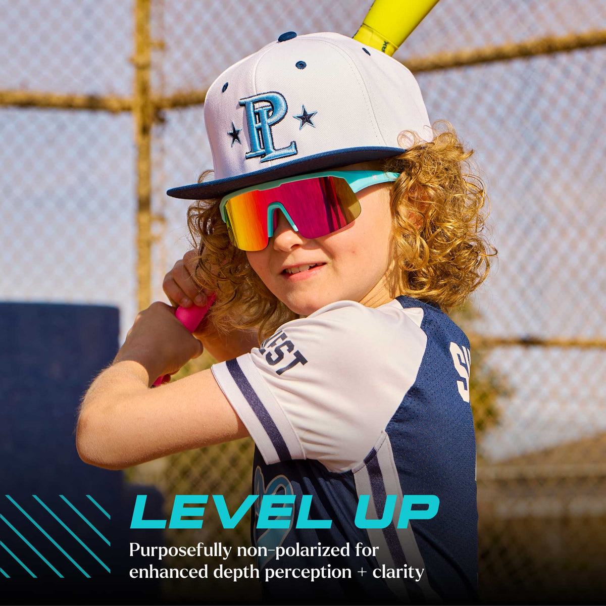 Level Up. Purposefully non-polarized for enhanced depth perception + clarity. Boy wearing Wild Card / Pink Sunset Kids Volts Sunglasses.